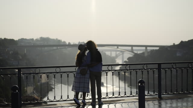 Paar-in-der-Silhouette,-umarmen-und-küssen-auf-Brücke