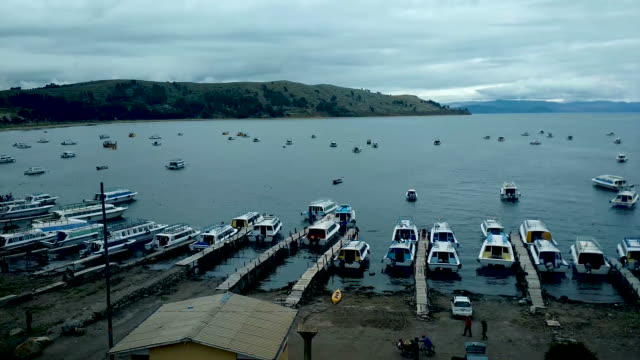 Lago-Titikaka-lleno-de-barcos-en-Copacabana,-Bolivia-con-un-cielo-nublado-y-las-personas-que-trabajan