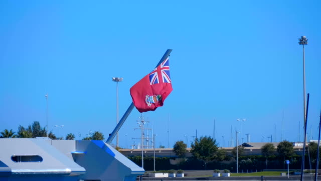 Eine-große-englische-Flagge,-die-auf-dem-Heck-eines-großen-Schiffes-montiert-ist,-das-im-Wind-flattert