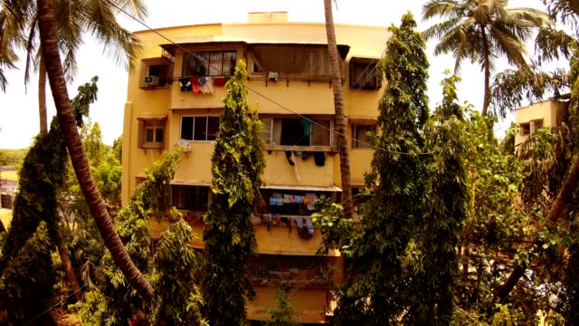 Vierstöckiges-Haus-in-Schlafzimmer-Gemeinde-Kleidung-trockenen-Wind-schwadet-Palmen-und-grüne-Bäume-Mumbai