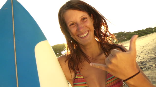 Lächelnde-junge-Frau,-die-surfen-Sie-mit-Ihrer-hand-sign