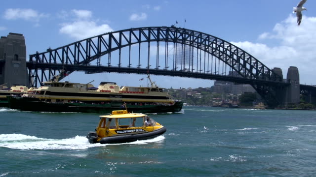Big-ferries-y-una-pequeña-taxi-acuático-y-pase-por-el-puente-del-puerto-de-Sydney