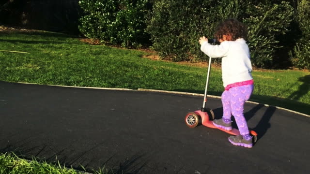 Slow-Motion-Kind-reiten-einen-Roller-im-park