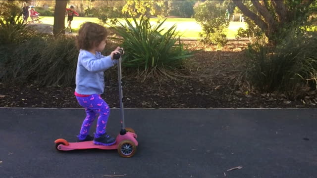 Slow-motion-child-ride-a-scooter-in-the-park