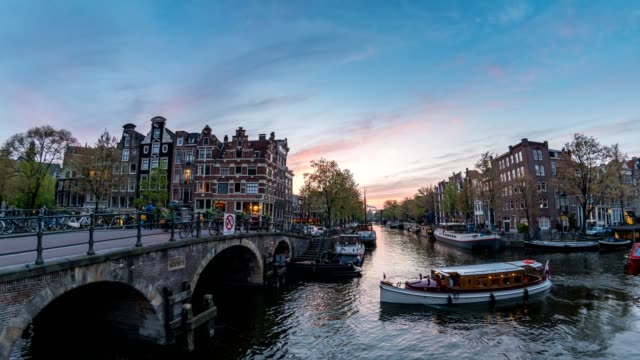 Amsterdam-city-skyline-day-to-night-timelapse-at-canal-waterfront,-Amsterdam,-Netherlands,-4K-Time-Lapse