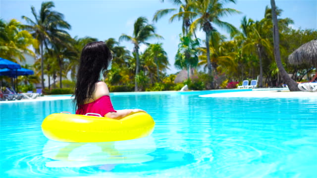 Happy-girl-having-fun-in-swimming-pool.-Beautiful-woman-in-outdoor-pool-at-luxury-hotel