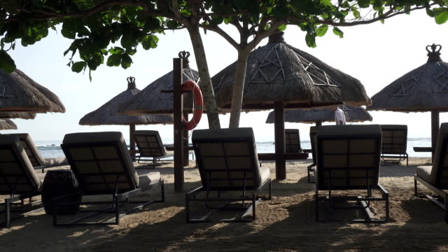 Sandstrand-des-tropischen-Resorts-mit-Sonnenschirmen-und-Chaise-lounges