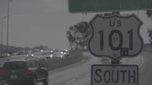 Cars-in-traffic-passing-by-US-101-South-sign-in-San-Francisco---uncolored-log-footage
