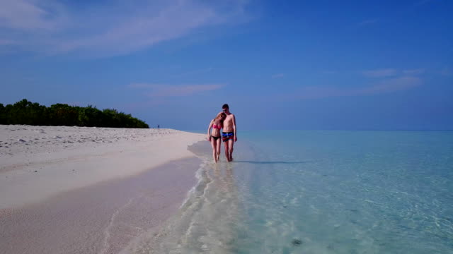 v03972-fliegenden-Drohne-Luftaufnahme-der-Malediven-weißen-Sandstrand-2-Personen-junges-Paar-Mann-Frau-romantische-Liebe-auf-sonnigen-tropischen-Inselparadies-mit-Aqua-blau-Himmel-Meer-Wasser-Ozean-4k