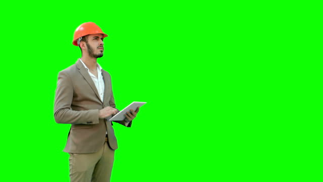 Engineer-in-safety-helmet-conducting-inspection-with-tablet-on-a-Green-Screen,-Chroma-Key