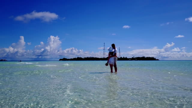 v03935-fliegenden-Drohne-Luftaufnahme-der-Malediven-weißen-Sandstrand-2-Personen-junges-Paar-Mann-Frau-romantische-Liebe-auf-sonnigen-tropischen-Inselparadies-mit-Aqua-blau-Himmel-Meer-Wasser-Ozean-4k