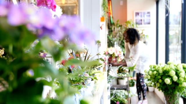Florist-with-pot-flower-walking-in-flower-shop-4k