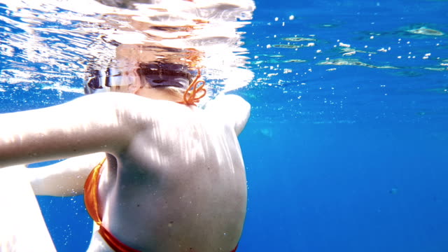 Inmersión-de-mujer-bajo-el-agua-en-la-máscara-de-buceo-snorkel