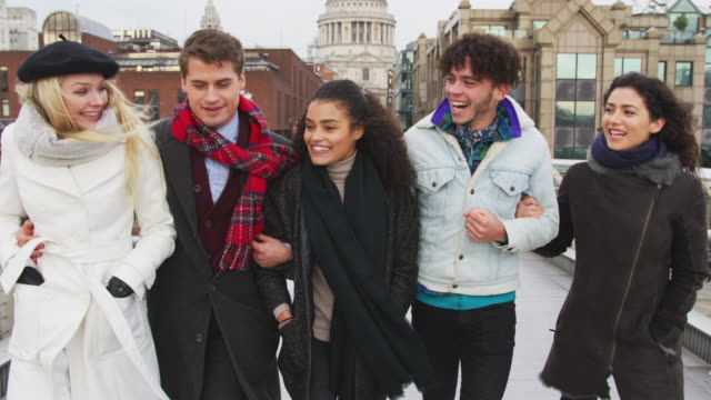 Grupo-de-jóvenes-amigos-caminando-sobre-puente-del-Milenio-en-Londres