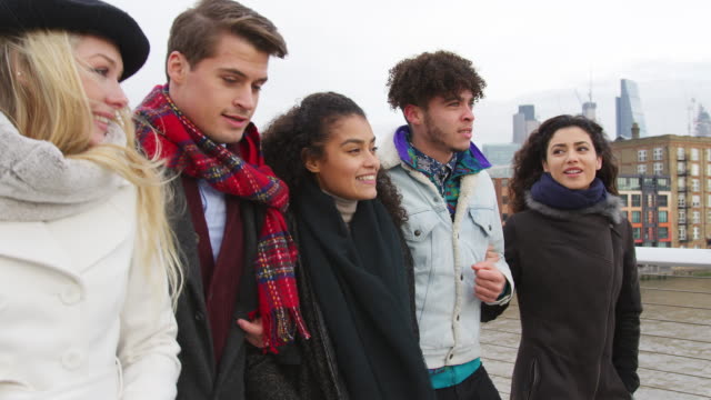 Gruppe-junger-Freunde-zu-Fuß-über-Millennium-Bridge-In-London