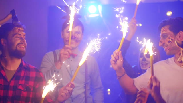 Crazy-friends-with-sparkler-dancing-at-the-halloween-party