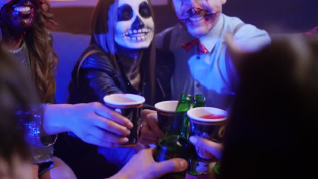 Group-of-friends-in-costumes-toasting-at-the-halloween-party