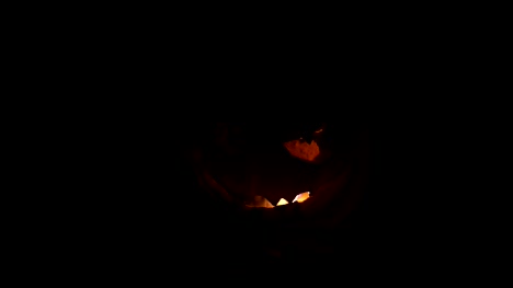 Horror-Halloween-concept.-Close-up-view-of-scary-dead-Halloween-pumpkin-glowing-at-dark-background.-Rotten-pumpkin-head.-Selective-focus