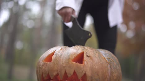 Halloween.-Girl-spends-a-knife-on-a-Halloween-pumpkin.