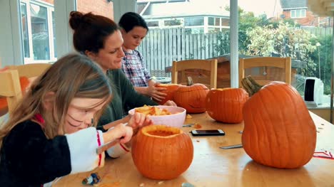 Young-family-carving-pumpkins-for-Halloween