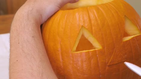 Man-Carves-a-Nose-in-a-Pumpkin-to-make-a-Jack-'o'-Lantern