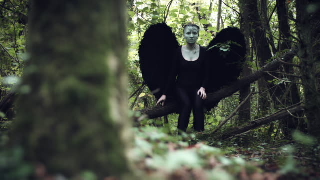 4k-Halloween-mujer-oscura-de-Angel-negro-alas-en-bosque-mirando-a-su-alrededor