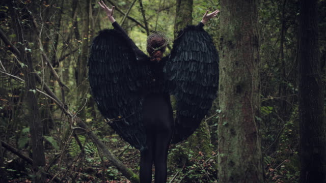 4k-Halloween-Dark-Angel-Frau-mit-schwarzen-Flügeln-im-Wald-Hände-aufstehen