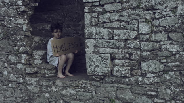 4k-Horror-Shot-of-an-Abandoned-Child-Holding-"Homeless"-on-cardboard