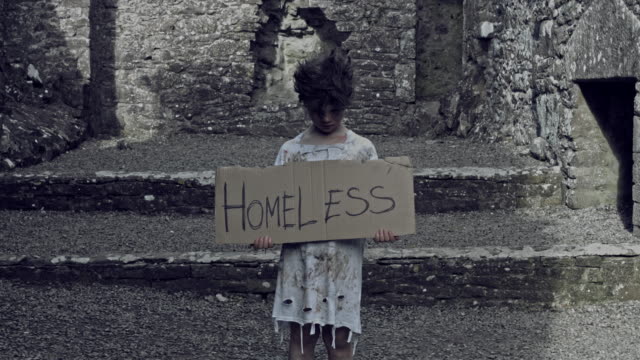 4k-Horror-Shot-of-an-Abandoned-Child-Holding-"Homeless"-on-cardboard