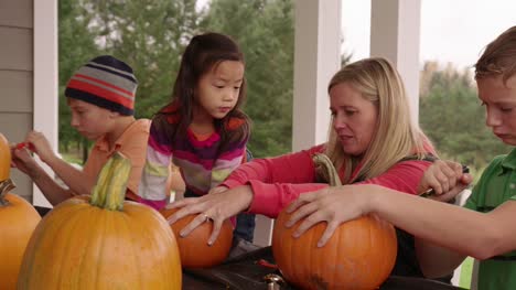 Mom-and-kids-carving-pumpkins-for-Halloween