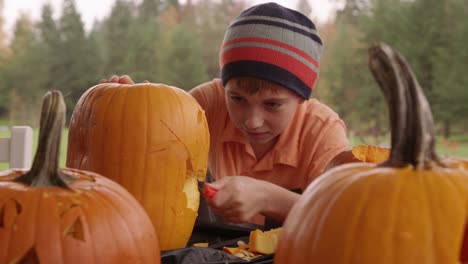 Young-boy-carving-pumpkin-for-Halloween