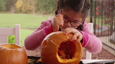 Young-girl-carving-pumpkin-for-Halloween
