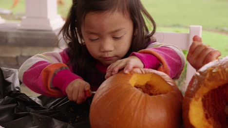 Young-girls-carving-pumpkin-for-Halloween