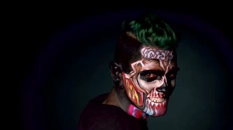 Man-with-bright-skull-make-up-and-stylish-haircut-touching-head