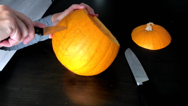 Female-hands-are-carving-a-Halloween-pumpkin