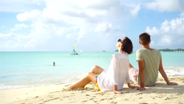Young-couple-on-white-beach-during-summer-vacation