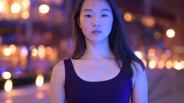 Portrait-Of-Beautiful-Asian-Woman-Smiling-Outdoors-At-Night