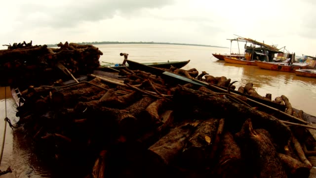 Boote-mit-Haufen-von-Brennholz-indianischen-Jungen-steht-in-kleinen-Rindenkrügen-auf-dem-Pier-Fluss-Ganges-Hochwasser-Manikarnika-brennende-ghat
