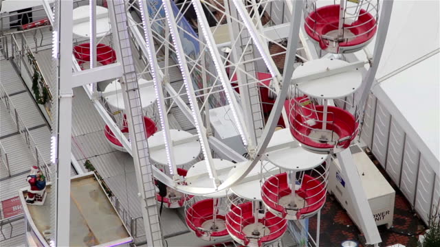 Close-Up-of-Ferris-Wheel-Cars-Spinning-Among-Christmas-Attractions-and-Lights
