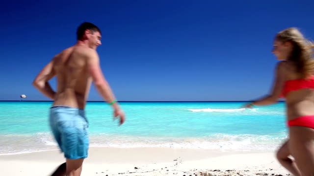 Junges-Paar-laufen-auf-das-Meer-am-Strand