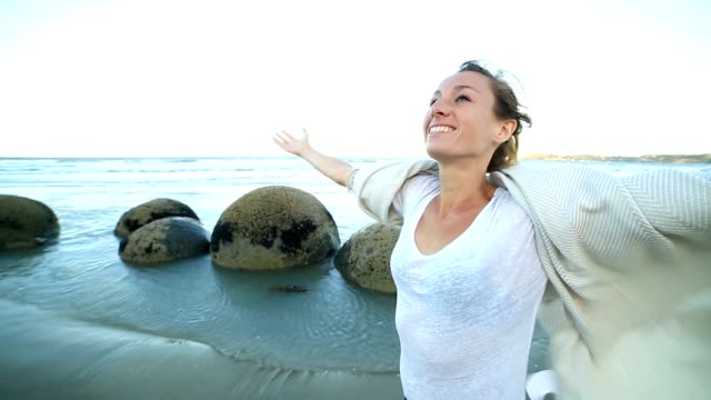 Moeraki-boulders:-Young-woman-enjoys-nature
