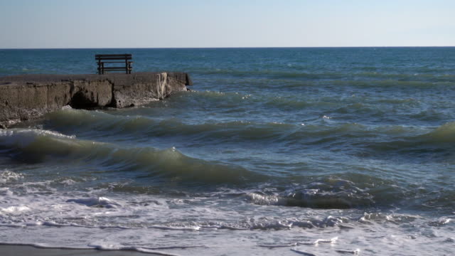Un-banco-de-solitario-en-un-Embarcadero-cerca-del-mar-en-una-playa-de-Grecia