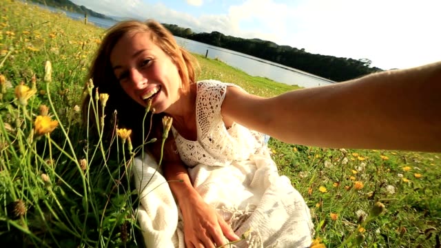 Joven-mujer-lleva-un-selfie-en-un-prado-de-flores-silvestres