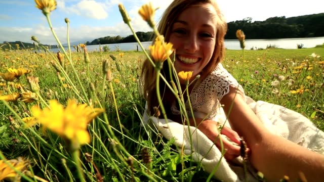 Joven-mujer-lleva-un-selfie-en-un-prado-de-flores-silvestres