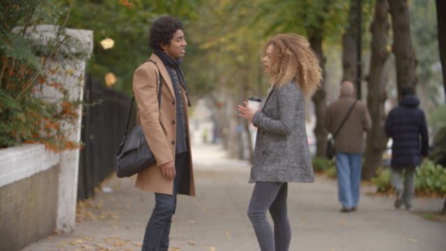 Stylish-Young-Couple-Talking-On-Fall-Street-In-City
