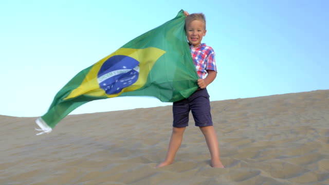 Kind-mit-brasilianischer-Flagge-am-Strand