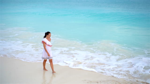 Happy-girl-at-beac-walking-in-shallow-water.-Top-view-on-a-woman-on-the-white-beach