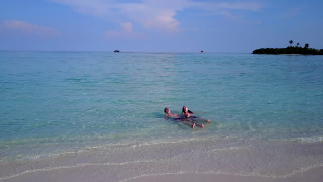 v04037-fliegenden-Drohne-Luftaufnahme-der-Malediven-weißen-Sandstrand-2-Personen-junges-Paar-Mann-Frau-romantische-Liebe-auf-sonnigen-tropischen-Inselparadies-mit-Aqua-blau-Himmel-Meer-Wasser-Ozean-4k