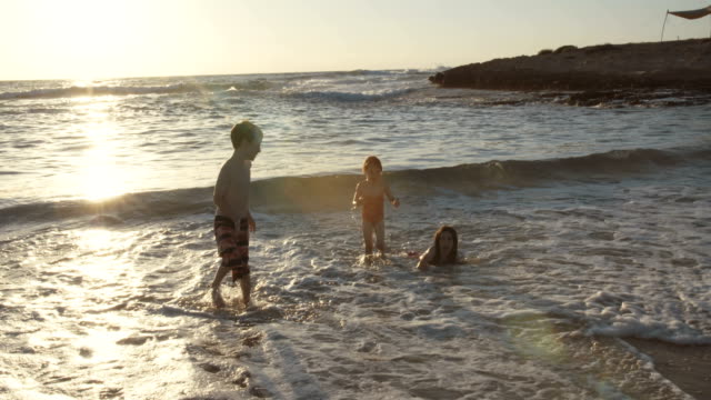 Tres-niños-jugando-en-la-playa-juntos