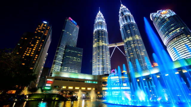 KLCC-PARK,-MALAYSIA---JULY-26-2017-:-Day-to-Night-Twin-Towers-And-KLCC-Park-Symphony-Fountain-Lake-Show-Every-Evening,-Landmark-Travel-Place-of-Kuala-Lumpur,-Malaysia-4K-Time-Lapse-(doly-pan-shot)